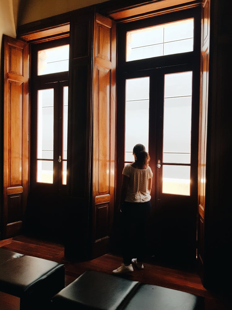 Back View Of A Girl Standing 
The Wood And Glass Door