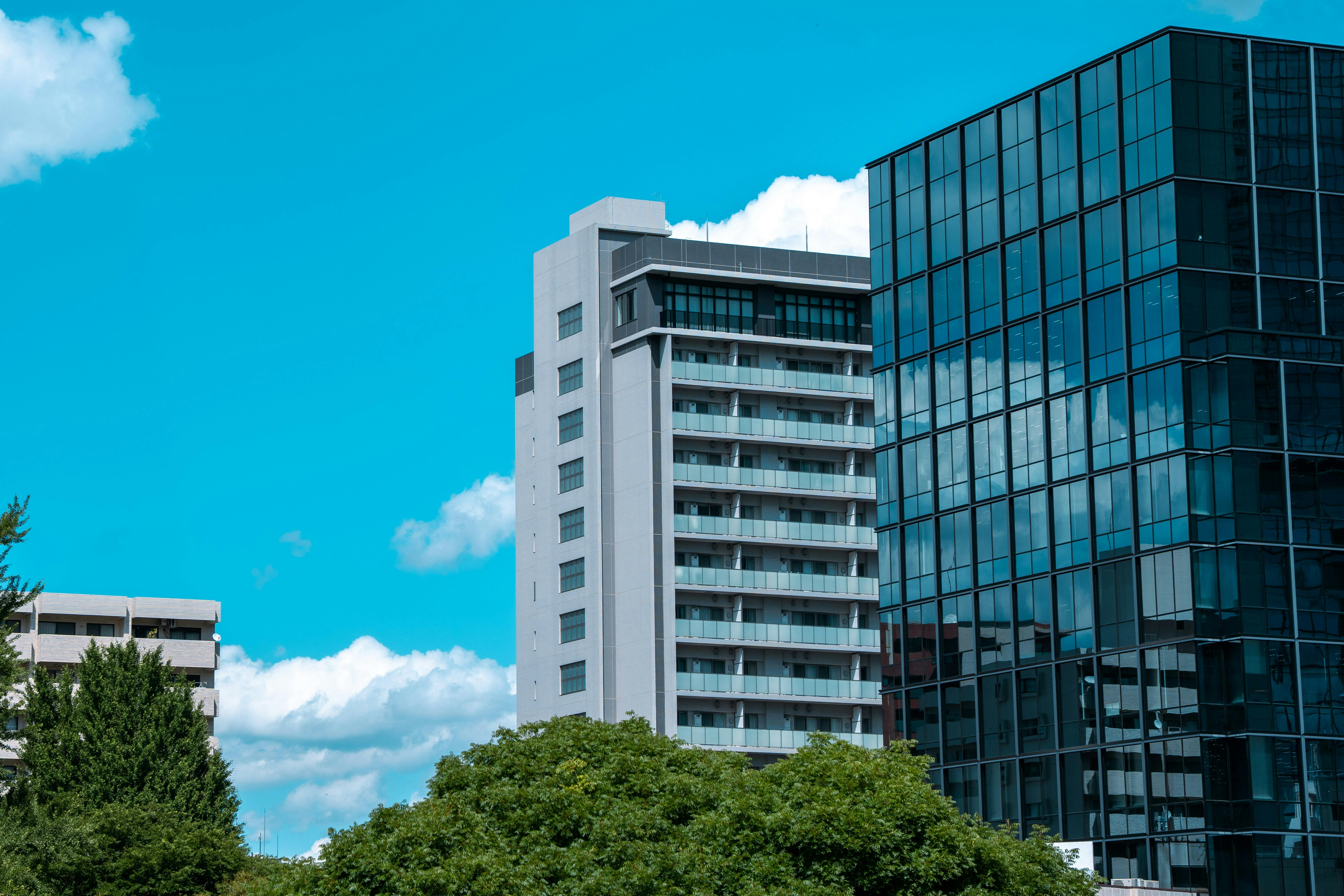 Modern buildings in Tokyo against a bright blue sky, showcasing contemporary urban architecture.