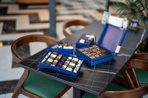Free Elegant display of artisan chocolates in blue boxes on a modern table setting. Stock Photo