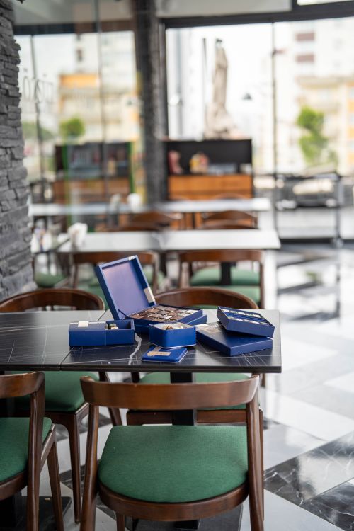 Free Blue boxes of almond chocolate on a café table in Kahramanmaraş, evoking modern leisure vibes. Stock Photo
