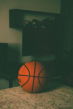 A nostalgic image of a basketball on a table, giving a vintage feel in an indoor setting.