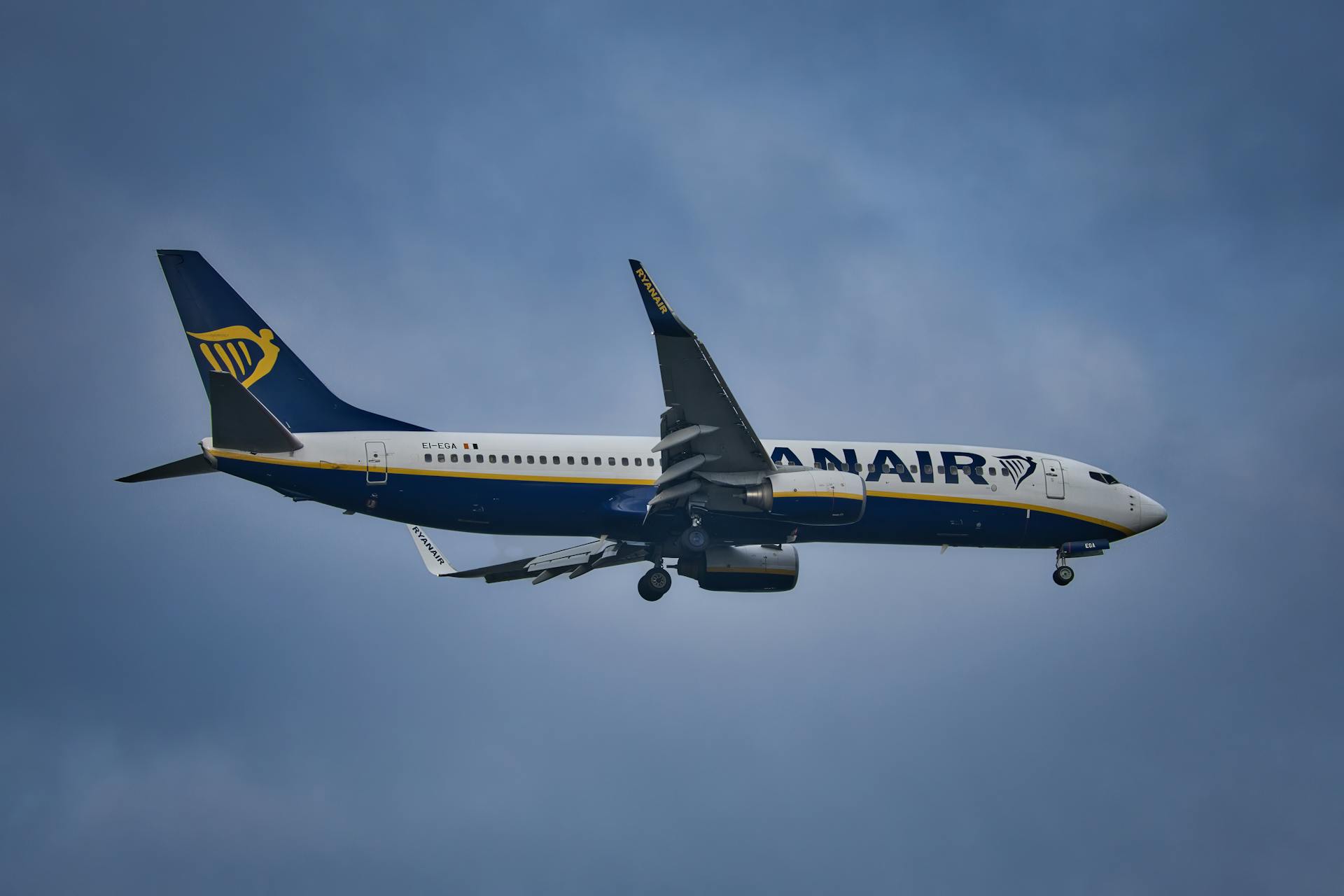 A Ryanair airplane in flight against a cloudy sky, showcasing air travel.