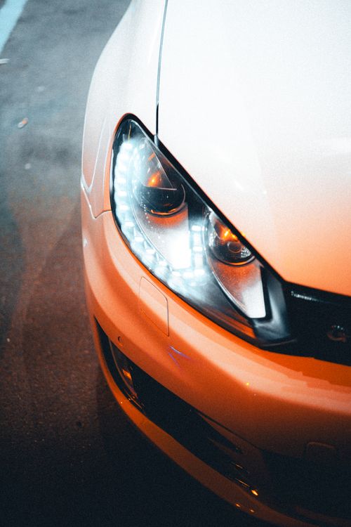 Free Dynamic close-up of a car's LED headlight captured in urban night setting. Stock Photo
