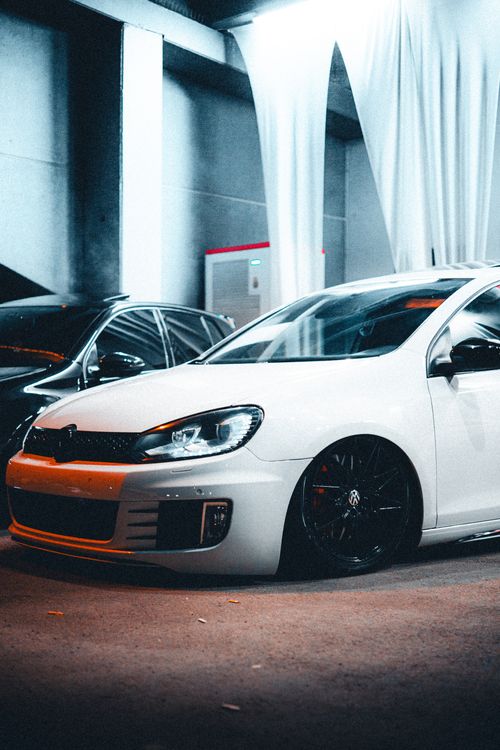 Free A modern white car parked in a stylish indoor garage setting with dramatic lighting. Stock Photo
