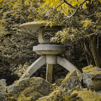 Serene image of a traditional Japanese stone lantern surrounded by lush greenery and foliage.（イメージ）