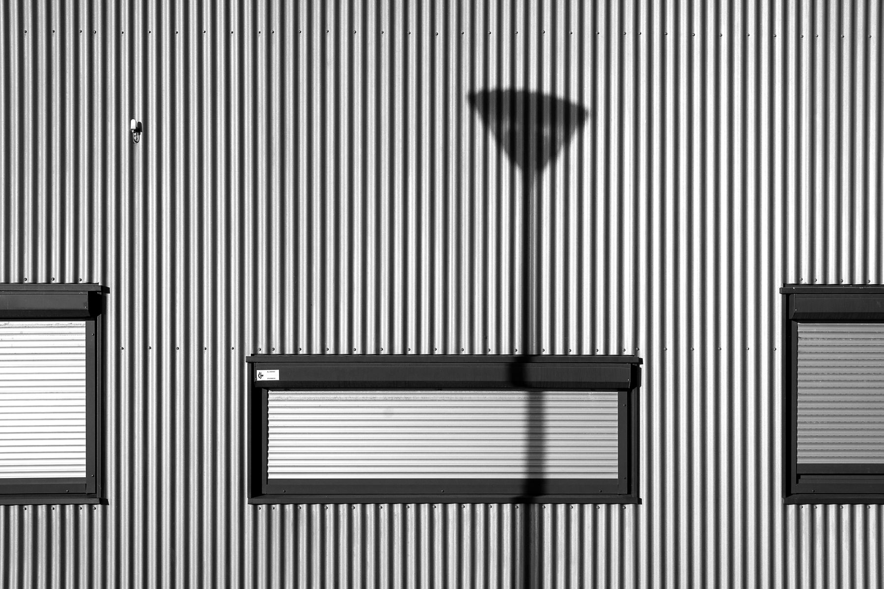 Corrugated metal facade with shuttered openings