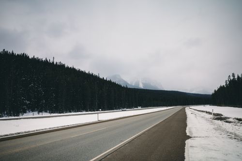Free Scenic winter road surrounded by snow and forest in British Columbia, Canada. Stock Photo