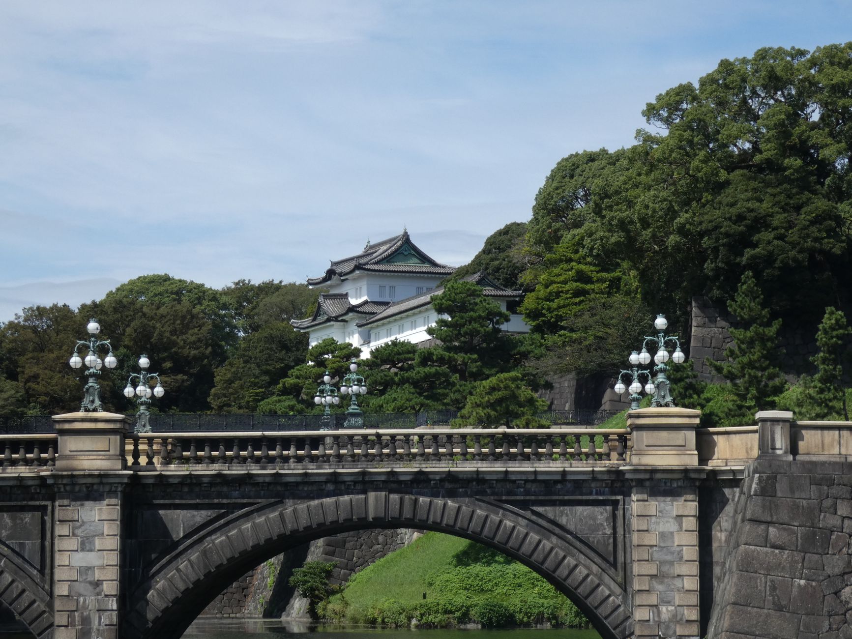 A serene shot of the Imperial Palace in Tokyo, Japan, framed by lush greenery and an iconic bridge.