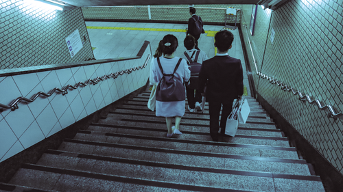 Free People walking down the stairs in a Tokyo subway station, showcasing urban commute. Stock Photo
