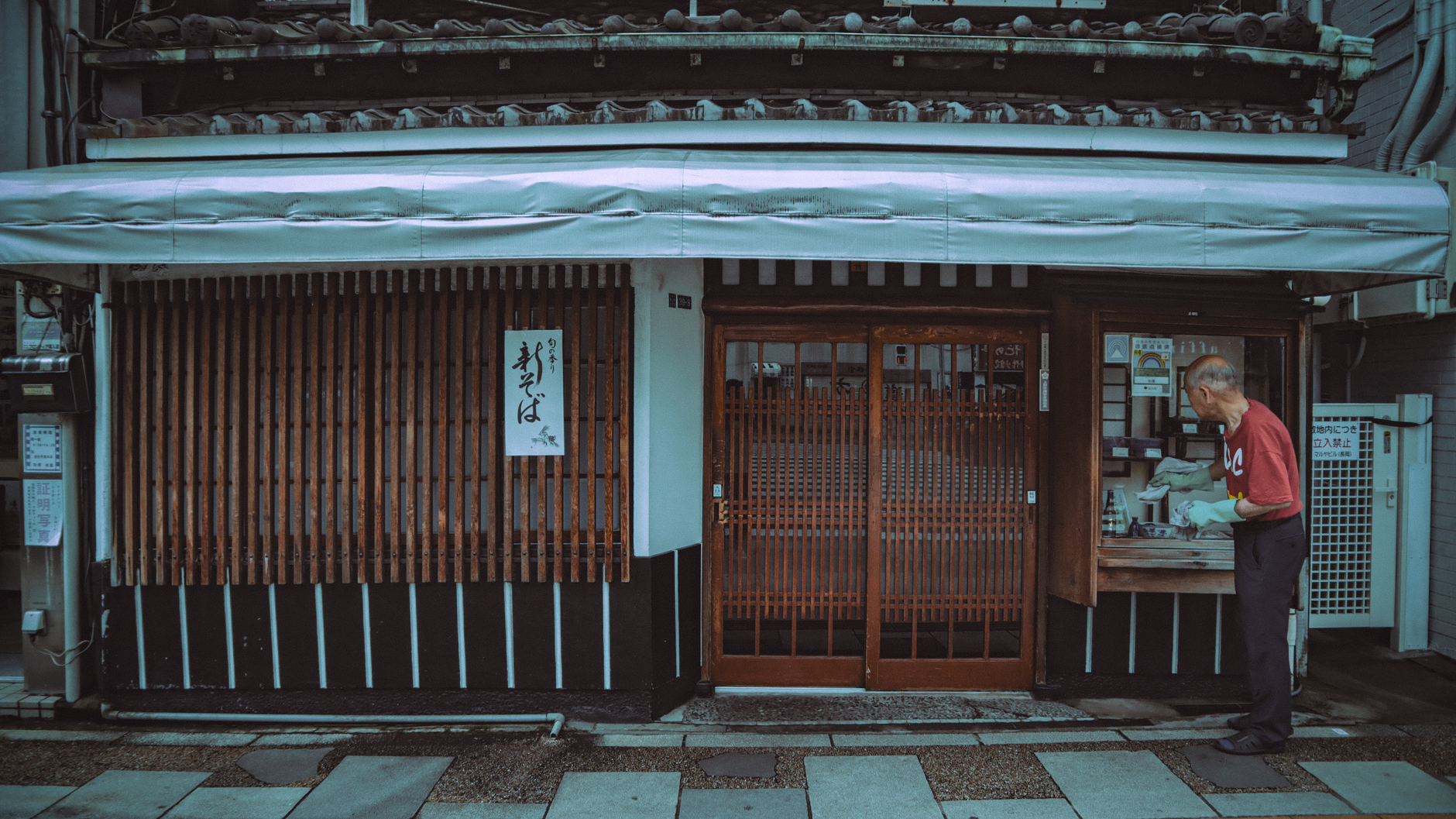 閉店後の静かな店内で、店主が一人で手帳に書き込んでいる写真