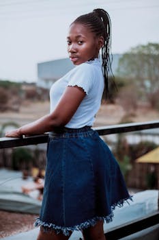 一个自信的年轻女子，在阳光明媚的户外，身着休闲装摆着姿势