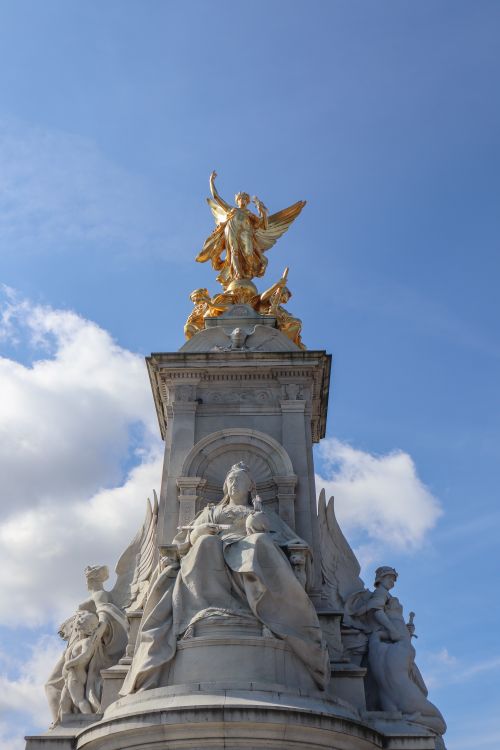 Free The Queen Victoria Memorial with golden statues in London under a bright blue sky. Stock Photo