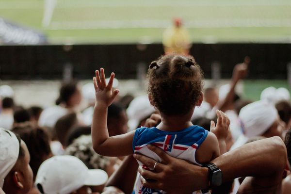 Dad lifting child at a football match