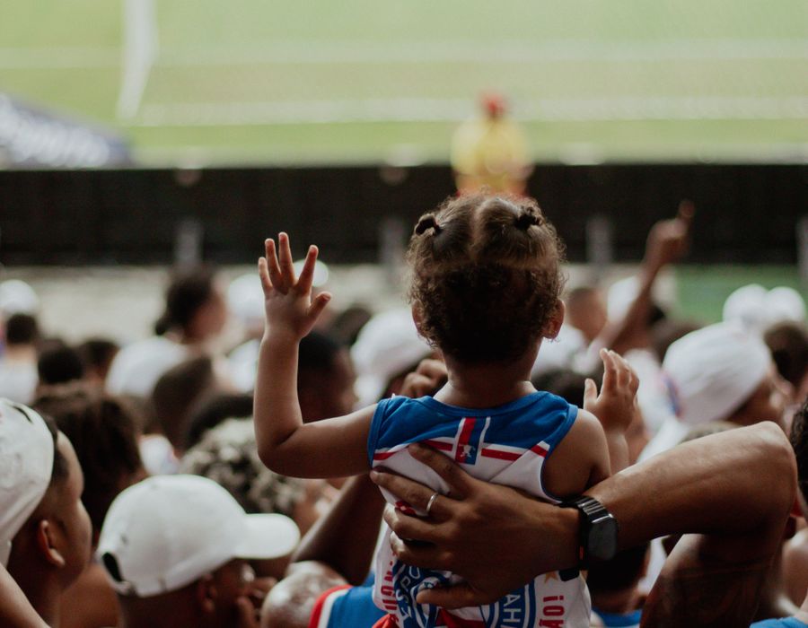 Parent lifting child at a football match