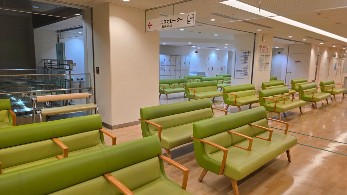 Empty hospital waiting area with green seats in Shibuya, Tokyo.