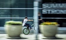 孩子骑着小轮车快速穿过城市，模糊的动作体现了速度感