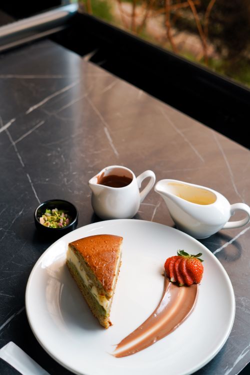 Free Delicious slice of cake with chocolate sauce and fresh strawberries on elegant tabletop. Stock Photo