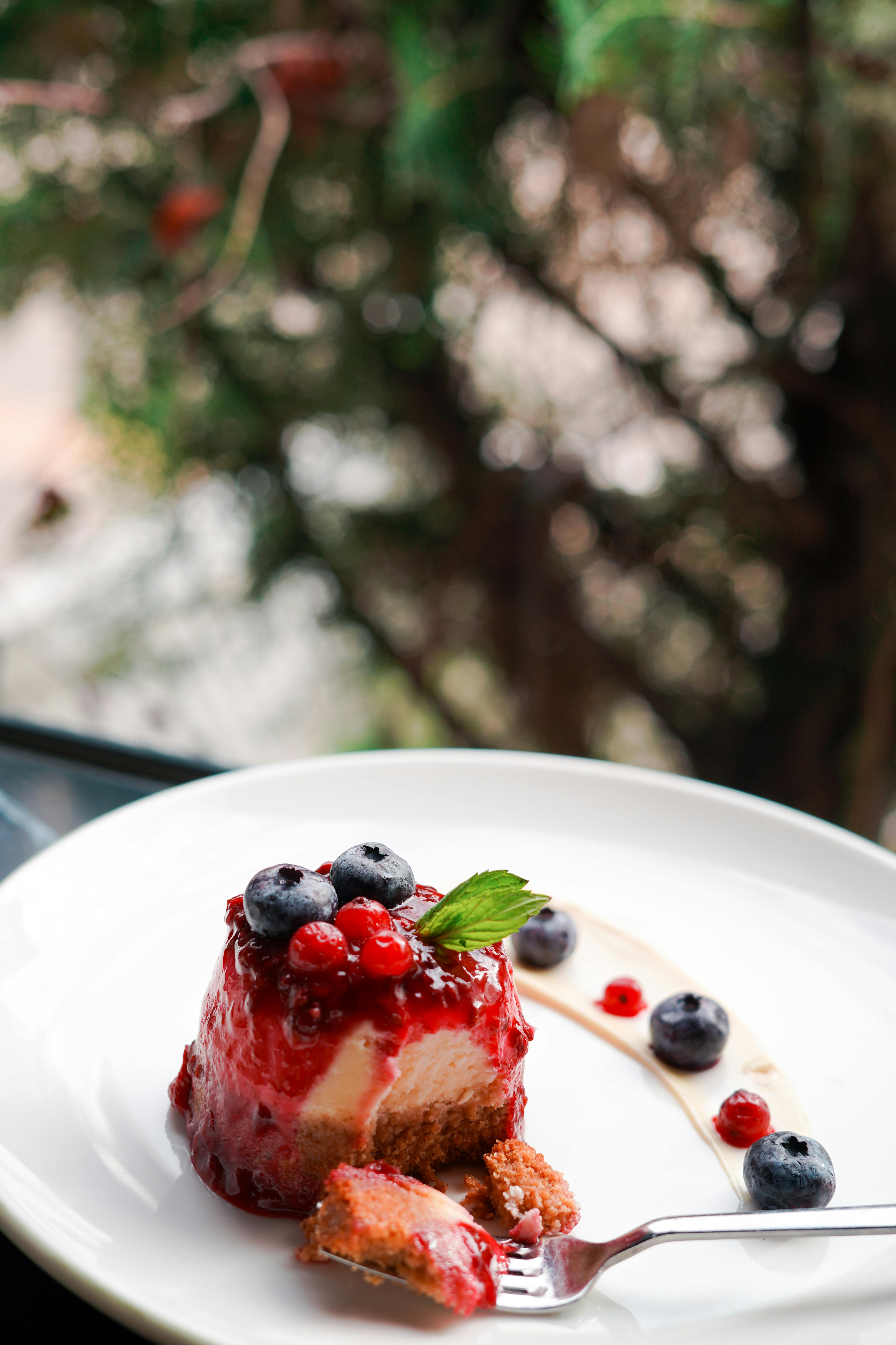 A mouthwatering dessert cake topped with fresh berries, perfect for a cozy café setting.