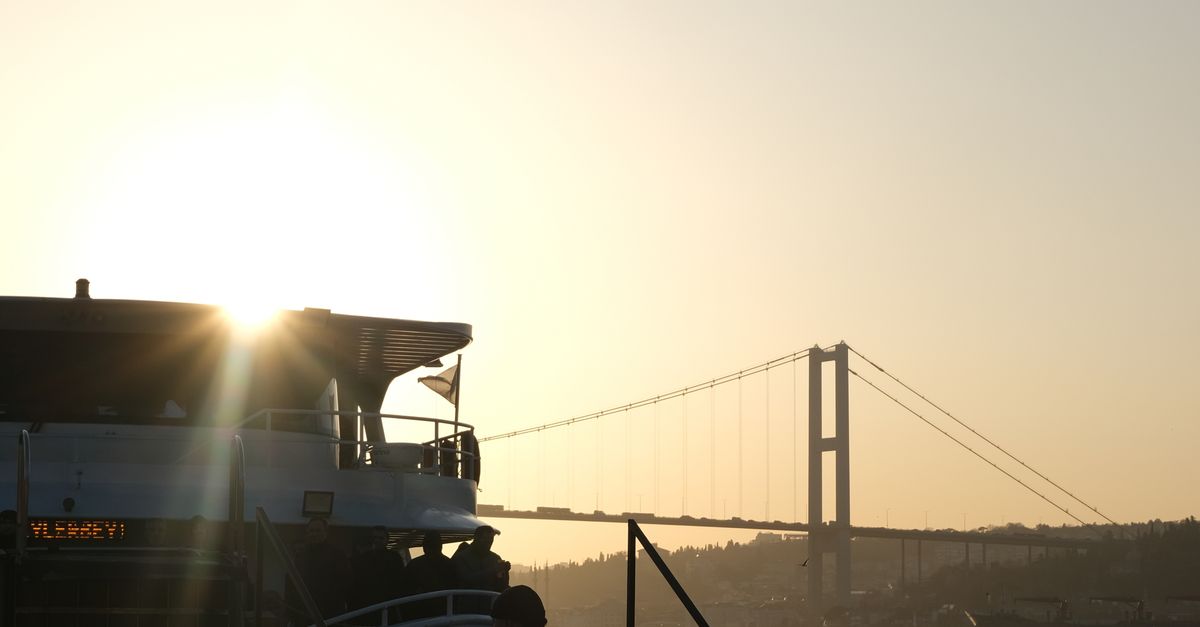 Rüyada Gemide Seyahat Etmek - Rüya Tabiri ve Anlamı - Serene view of a ship by the Bosphorus Bridge during sunset in İstanbul, Türkiye.