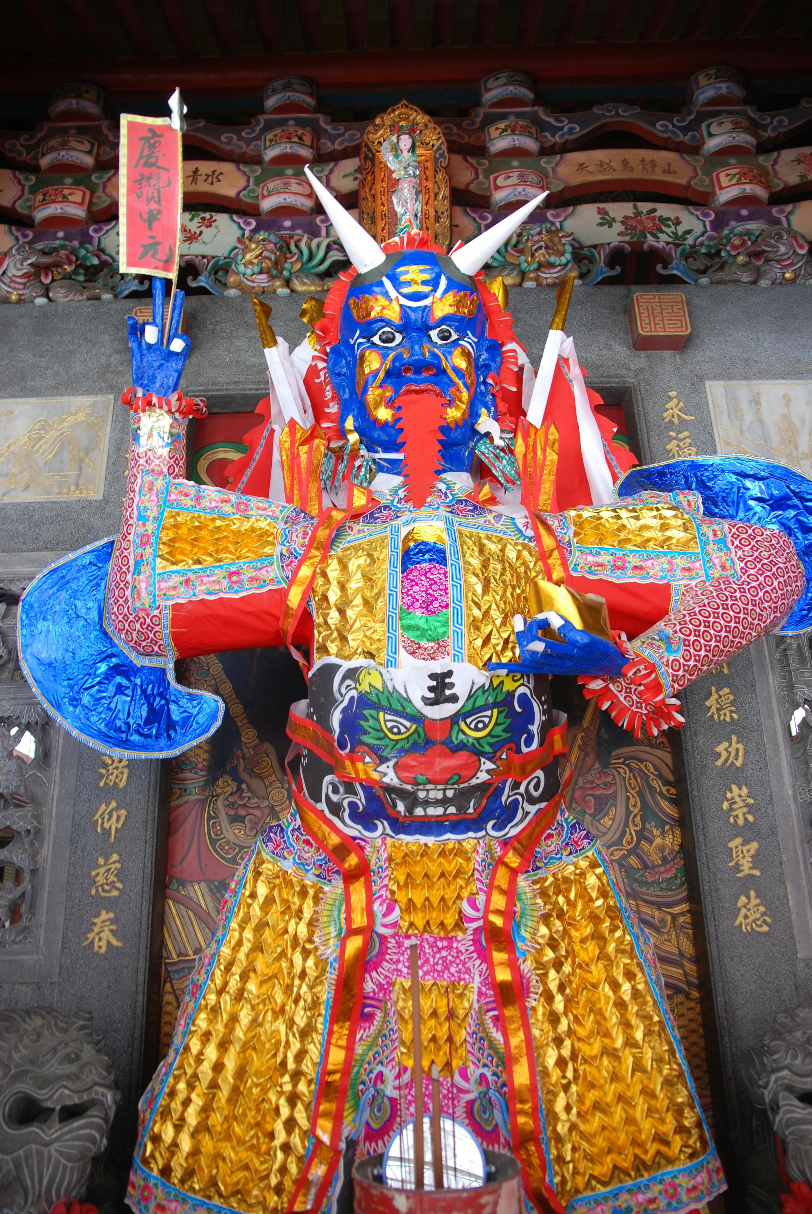 Colorful ornate dragon deity statue in a traditional temple setting.