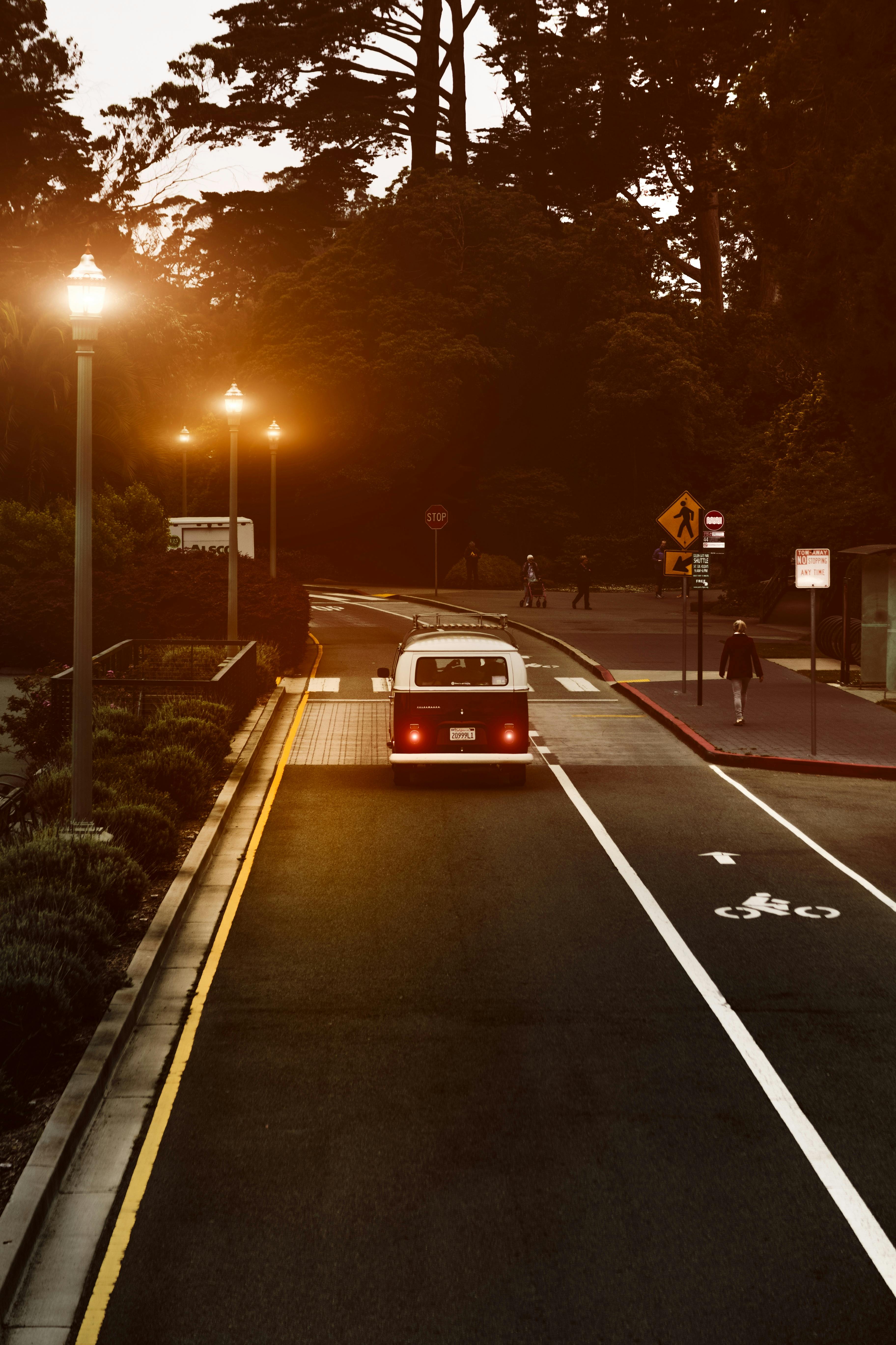 A vintage van journeys through San Francisco under warm streetlights at twilight.