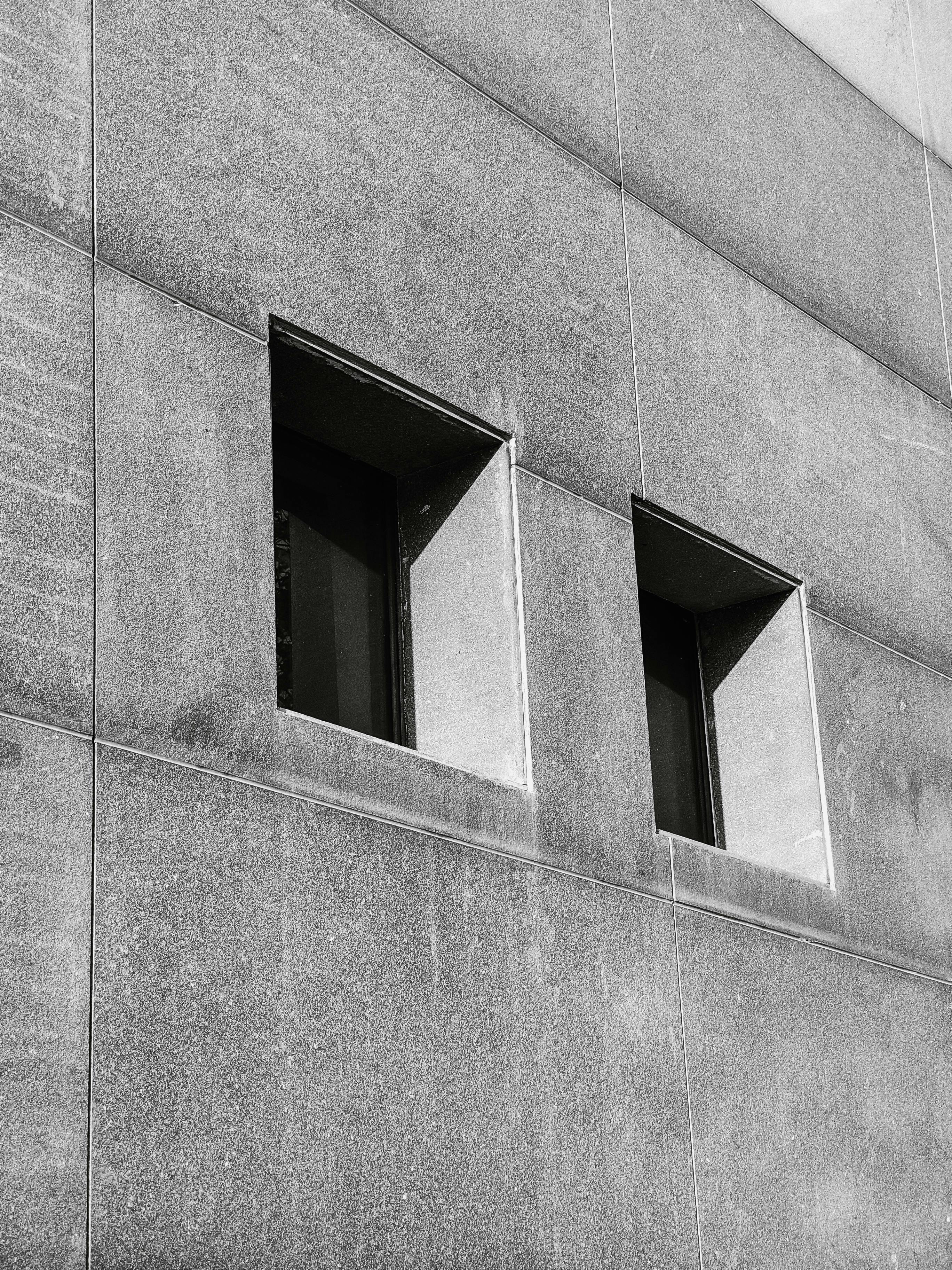 Gratis Fotografía en blanco y negro de dos ventanas cuadradas en un edificio moderno de hormigón. Foto de stock