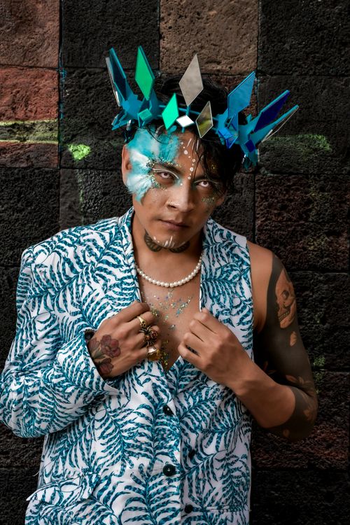 Free Striking portrait of a person with artistic makeup and geometric crown against a textured background. Stock Photo
