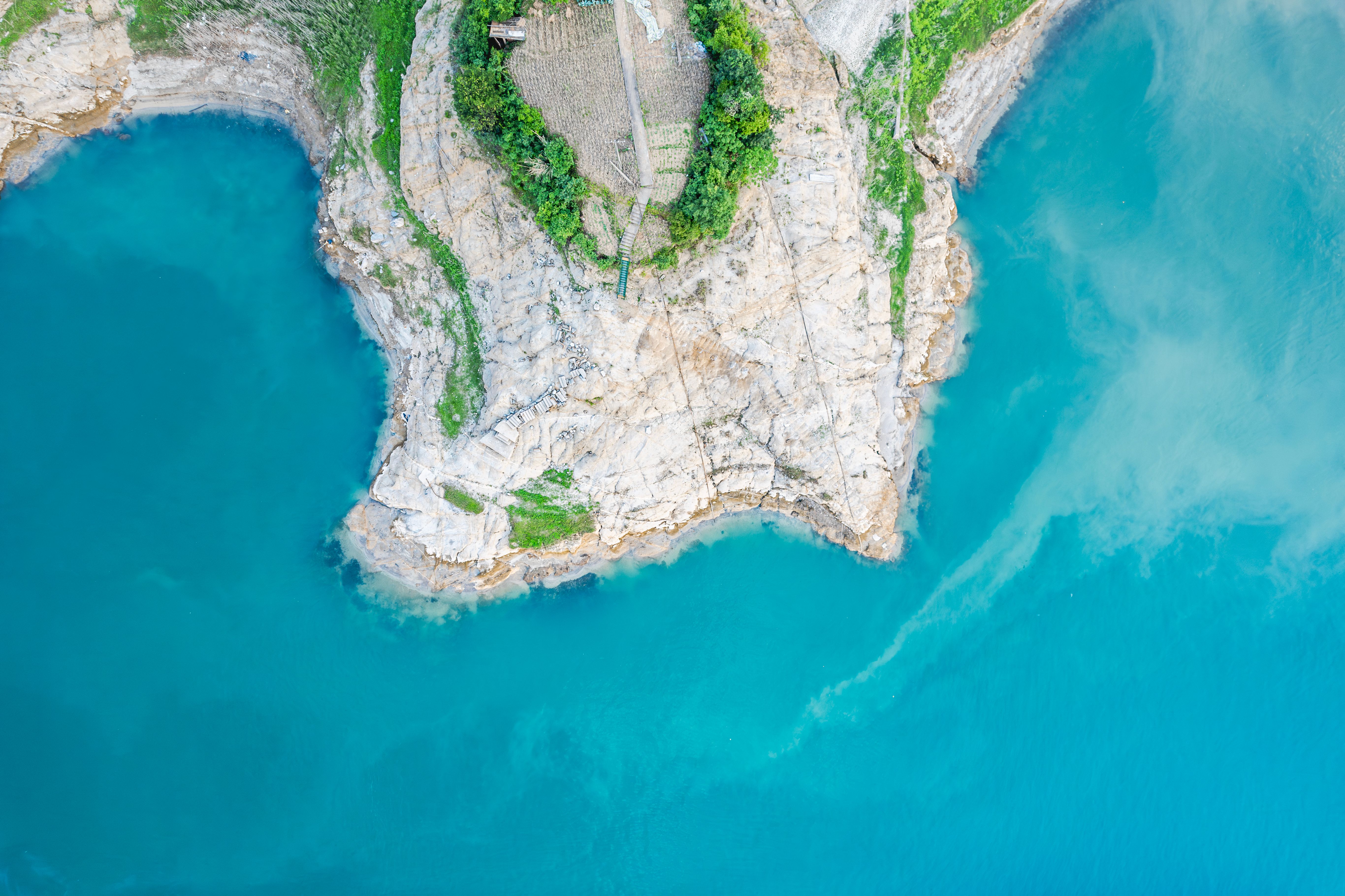 Aerial View of Rugged Cliff and Turquoise Waters · Free Stock Photo
