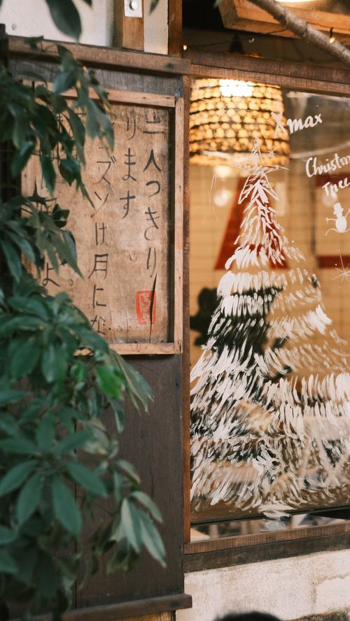 Free Cozy window display with Christmas tree and festive decorations reflecting a rustic aesthetic. Stock Photo