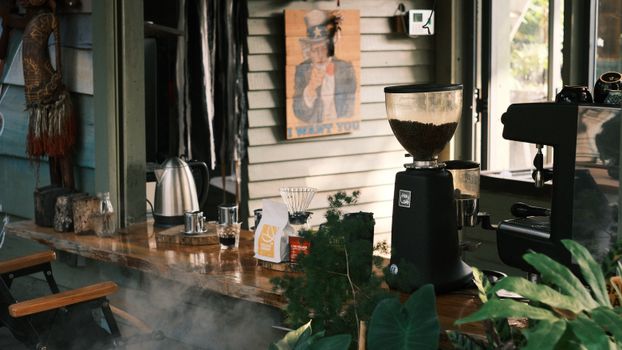 Warm coffee shop interior featuring an espresso machine and common brewing equipment.