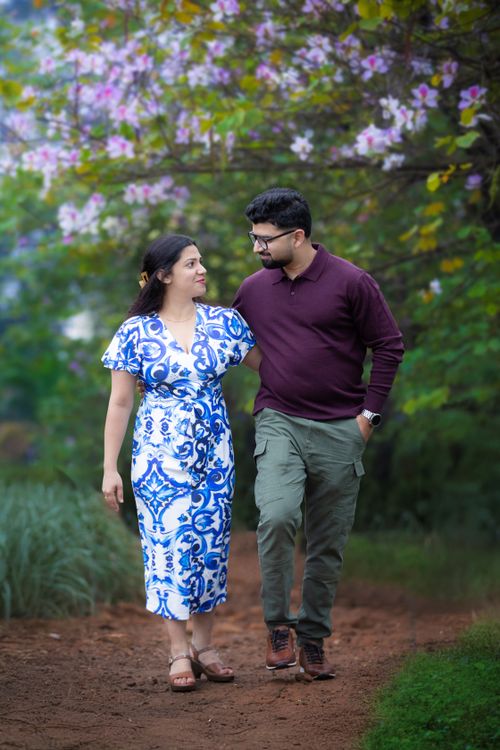 Free Happy couple walking together in blooming garden, embracing nature's beauty in spring. Stock Photo