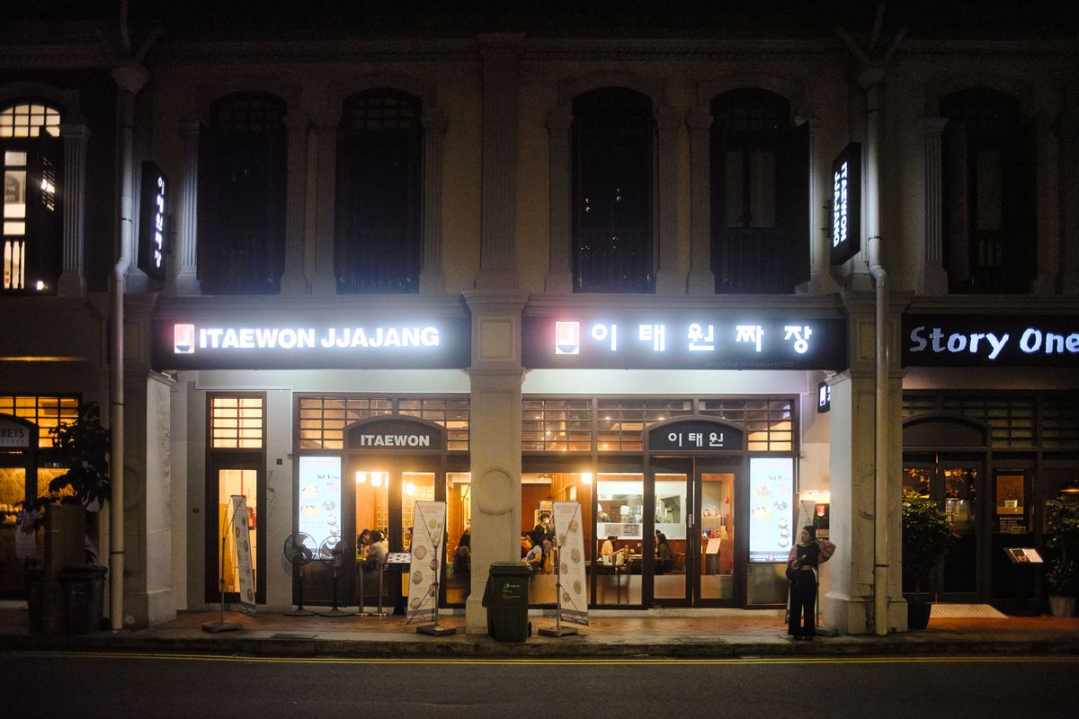 A night street in Itaewon with restaurant signs and city lights