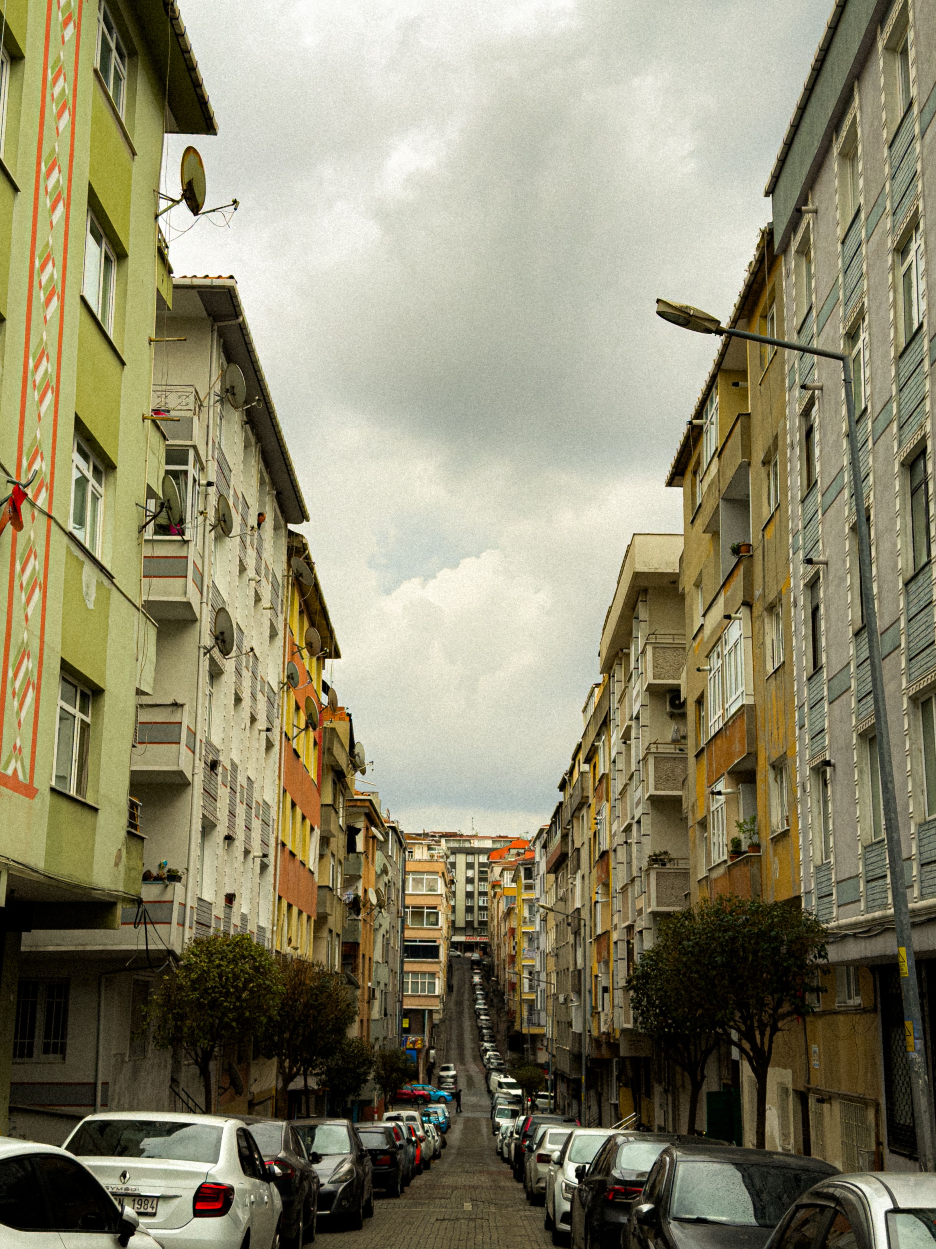 Urban Street with Colorful Buildings and Overcast Sky · Free Stock Photo