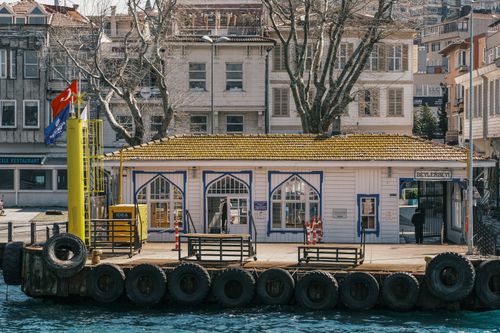 Free A picturesque view of the historic Beylerbeyi Dock in Istanbul, featuring Turkish architecture and flags. Stock Photo