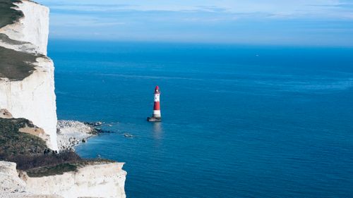 Free Scenic view of Beachy Head Lighthouse and chalk cliffs in England with clear blue ocean. Stock Photo
