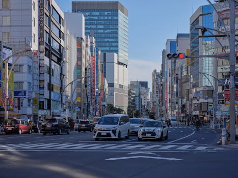Dynamic scene of traffic and skyscrapers on a busy Tokyo street.