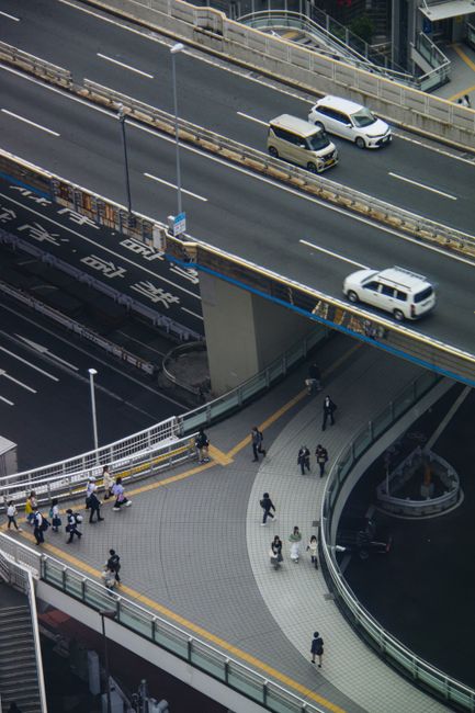 Aerial perspective of Tokyo's highways and pedestrian paths bustling with activity.