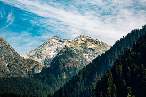 Free Snow-capped mountains with lush forests under a clear blue sky, perfect for nature lovers. Stock Photo