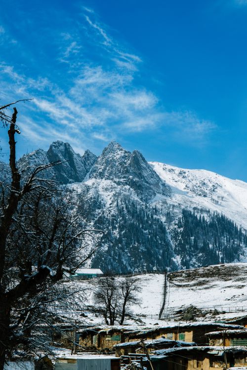 Free Scenic view of a snowy mountain landscape with a vibrant blue sky, perfect for winter themes. Stock Photo