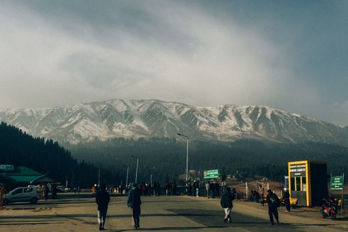 Free People enjoying a winter day near snow-covered mountains, creating a picturesque outdoor scene. Stock Photo