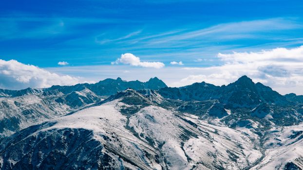 Breathtaking view of snow-covered mountains under a vibrant blue sky, perfect for nature enthusiasts.