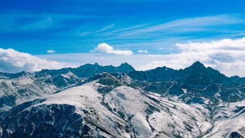 Free Breathtaking view of snow-covered mountains under a vibrant blue sky, perfect for nature enthusiasts. Stock Photo
