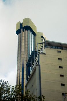 High-rise building with unique architecture under a cloudy sky.