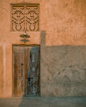 A rustic wooden door on a traditional building facade in Dubai, showcasing Middle Eastern architecture.