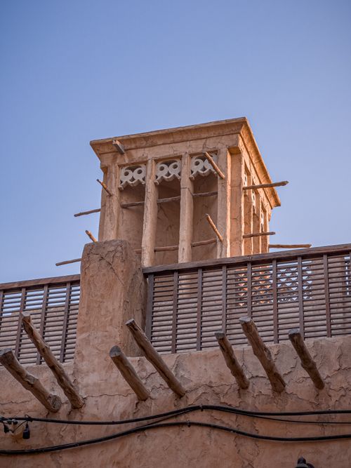 Free View of a traditional wind tower under clear blue skies in the historic Al Seef area, Dubai. Stock Photo