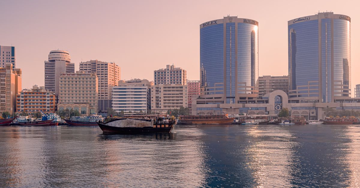 Dubai Marina skyline with illuminated skyscrapers reflected in the water at night