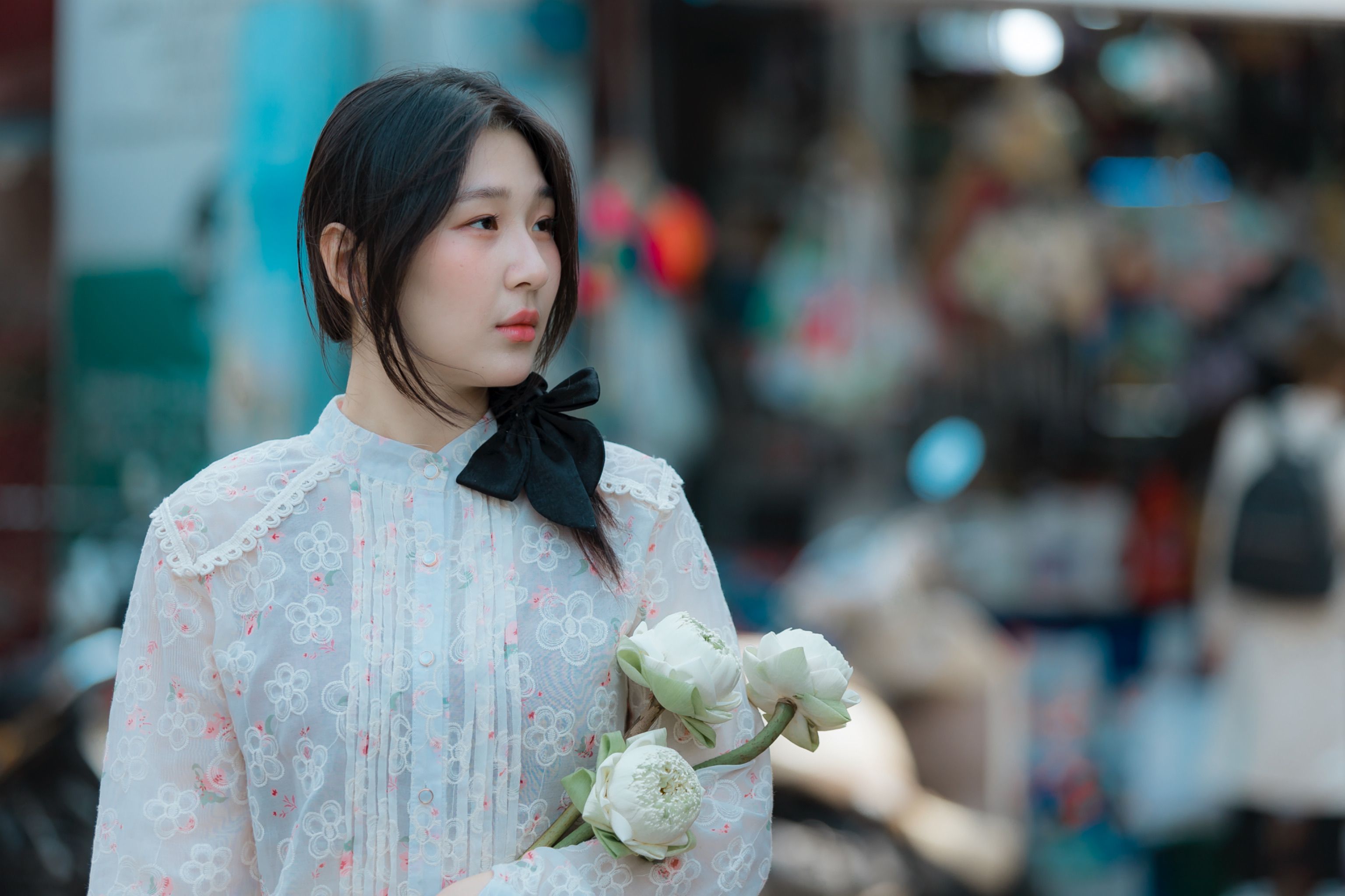 Woman in Floral Dress Holding White Flowers Outdoors · Free Stock Photo