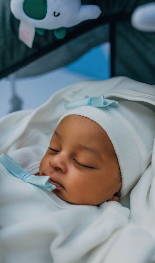 Free Close-up of a serene newborn baby sleeping in soft white and blue blankets. Stock Photo