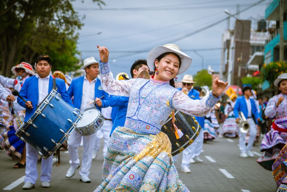 Vibrant street parade featuring dancers in traditional costumes and lively drummers.