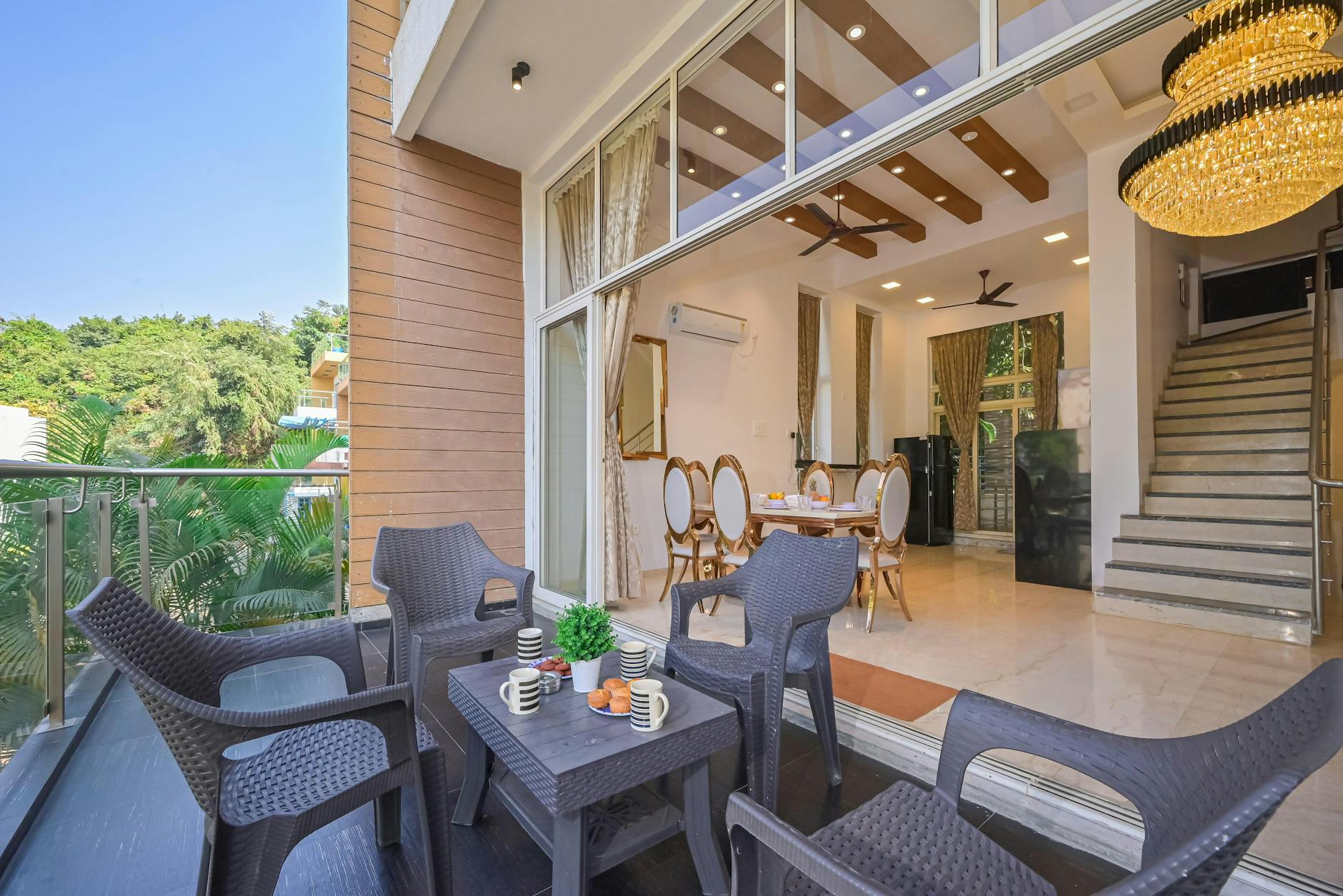 Top 10 Exterior Renovation Trends for a Modern Home in 2025 1 Chic indoor-outdoor space with elegant dining, cozy seating, and lush greenery.